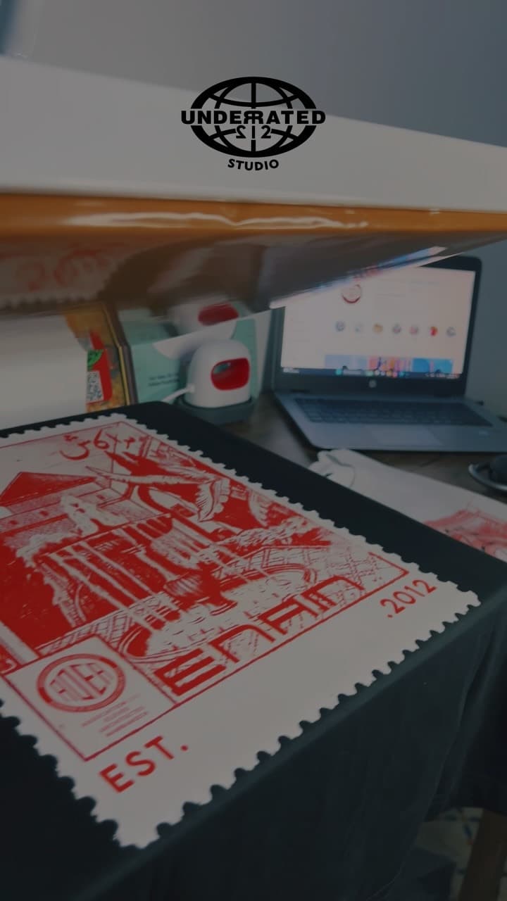 A freshly pulled red screen print drying on the press in the studio